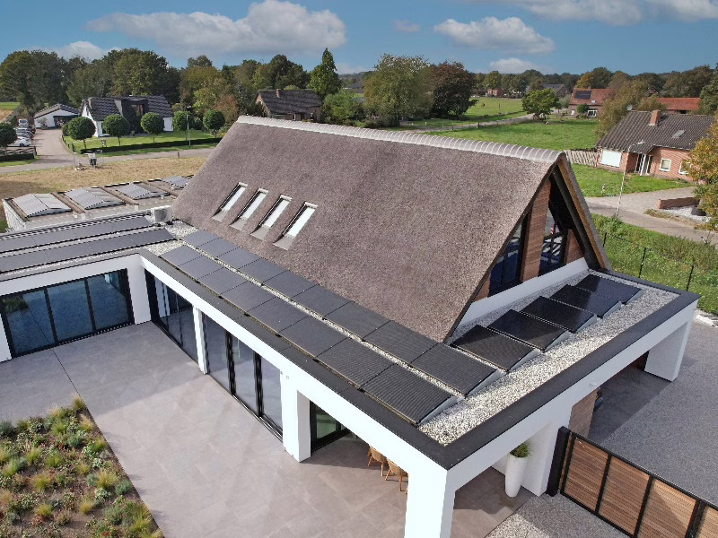 Moderne nieuwbouwwoning met rieten kap en zonnepanelen, klaar voor een naadloze gietvloer