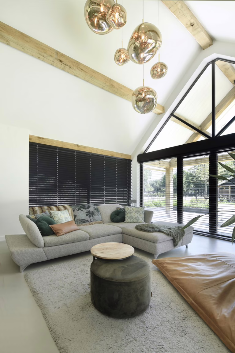 Design Woonbeton in Schijf, warme grijze microcement vloer in de woonkamer met hoge open kap