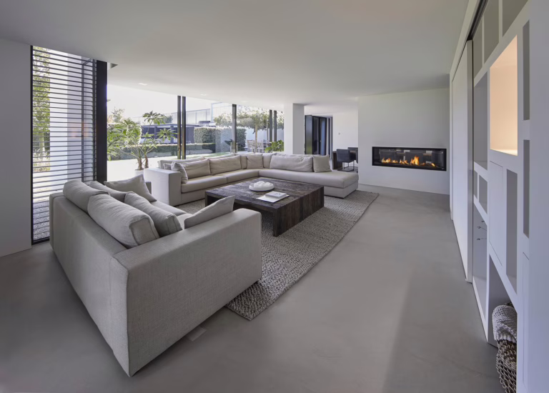 Design Woonbeton in Breda in de woonkamer met beige banken en open haard