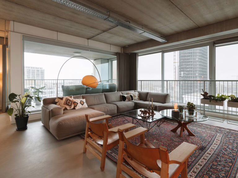 Lavasteen gietvloer Eindhoven — zithoek met boekenkast en Scandinavische designklassiekers.
