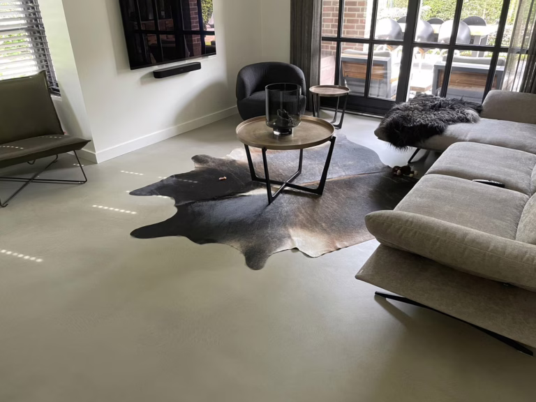 Doorlopende design woonbeton Sint-Michielsgestel in Stone Grey met koeienhuid vloerkleed en salontafel