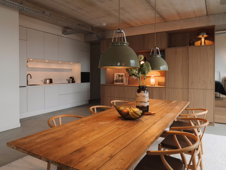 Lavasteen gietvloer Eindhoven — eetkamer met houten eettafel en Wishbone Chairs.