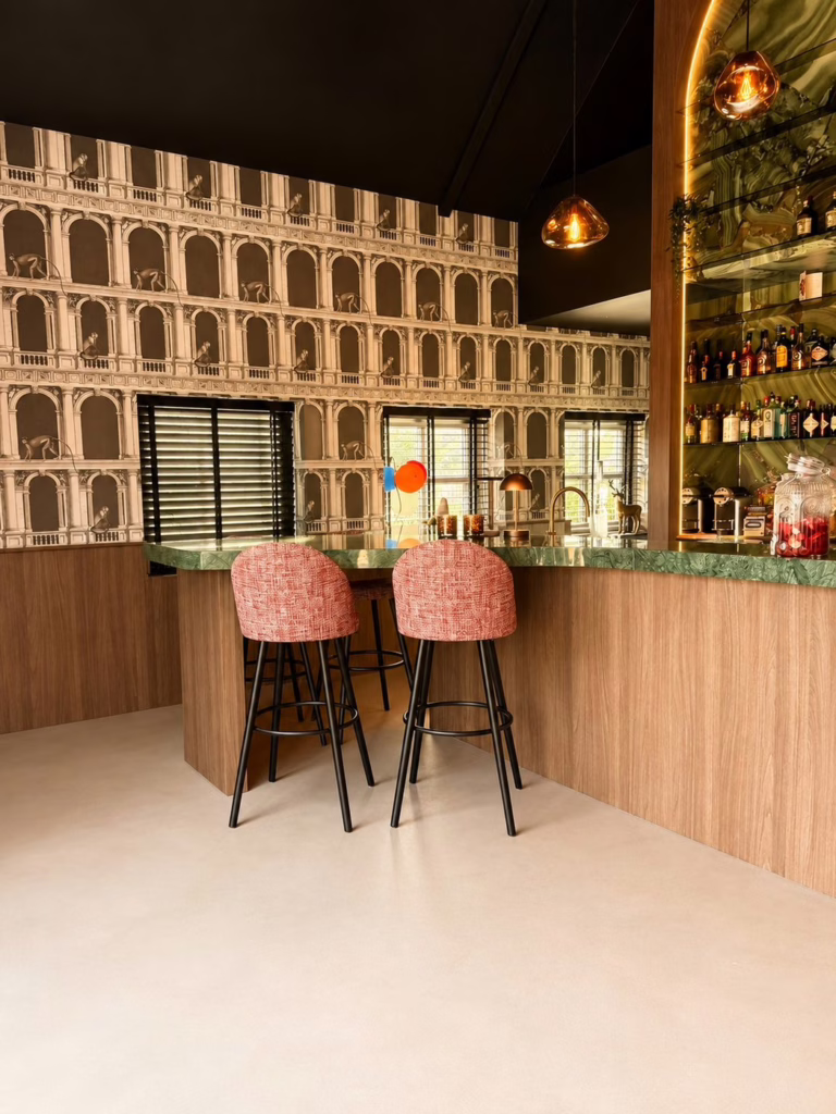 Detail Minimal Sand gietvloer Best — moderne bar met sfeervolle verlichting en houten paal.