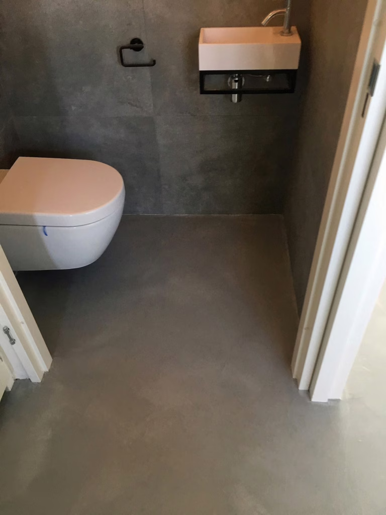 Venetiaans woonbeton Waalre in het toilet — naadloze doorloop van hal naar toiletruimte.