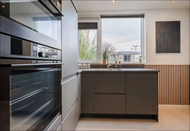 Lavasteen Premium greige gietvloer bij kookeiland — moderne keuken Son en Breugel