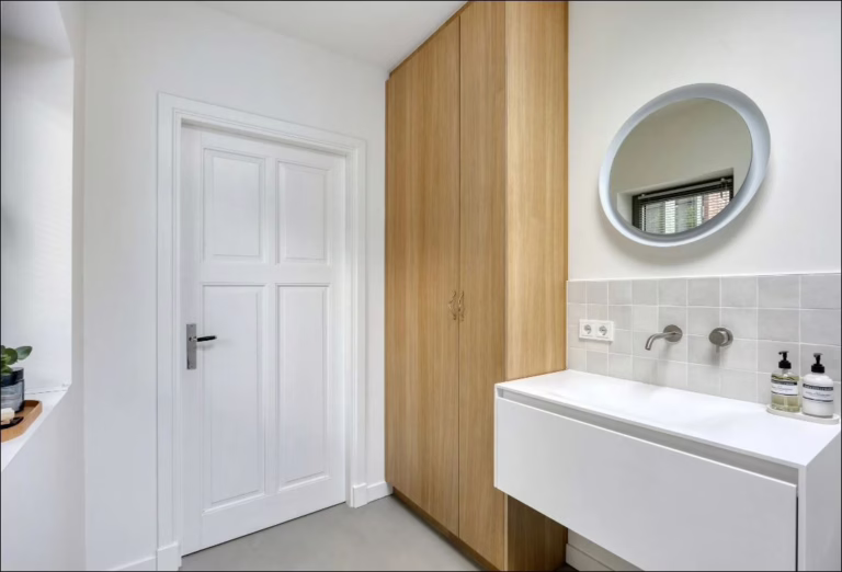 Detail badkamer met ronde spiegel, eikenhouten kast en Lavasteen gietvloer in Lava — Eindhoven