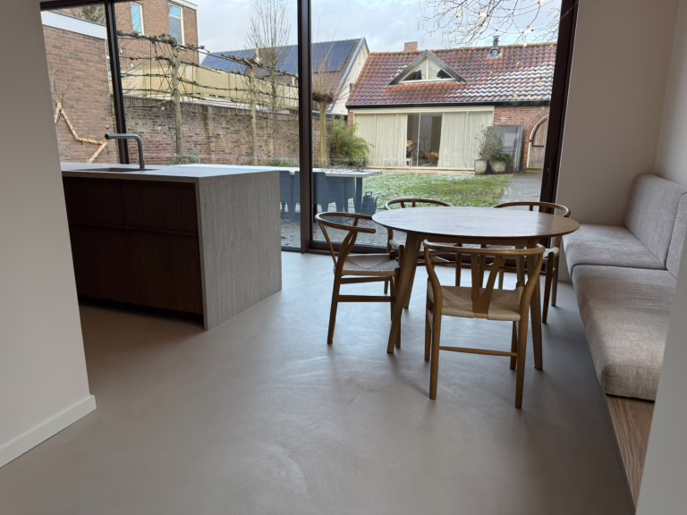 Moderne Minimal Sand kwartsiet gietvloer met travertijnen kookeiland en Japandi eethoek — Wijchen