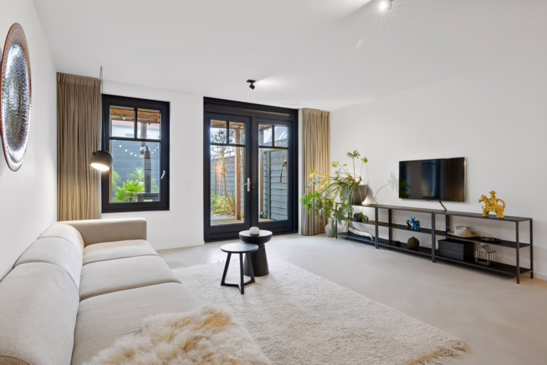 Woonkamer met Venetiaans Woonbeton in Grigio Primavera — naadloze off-white microcement vloer in een modern interieur in Helmond
