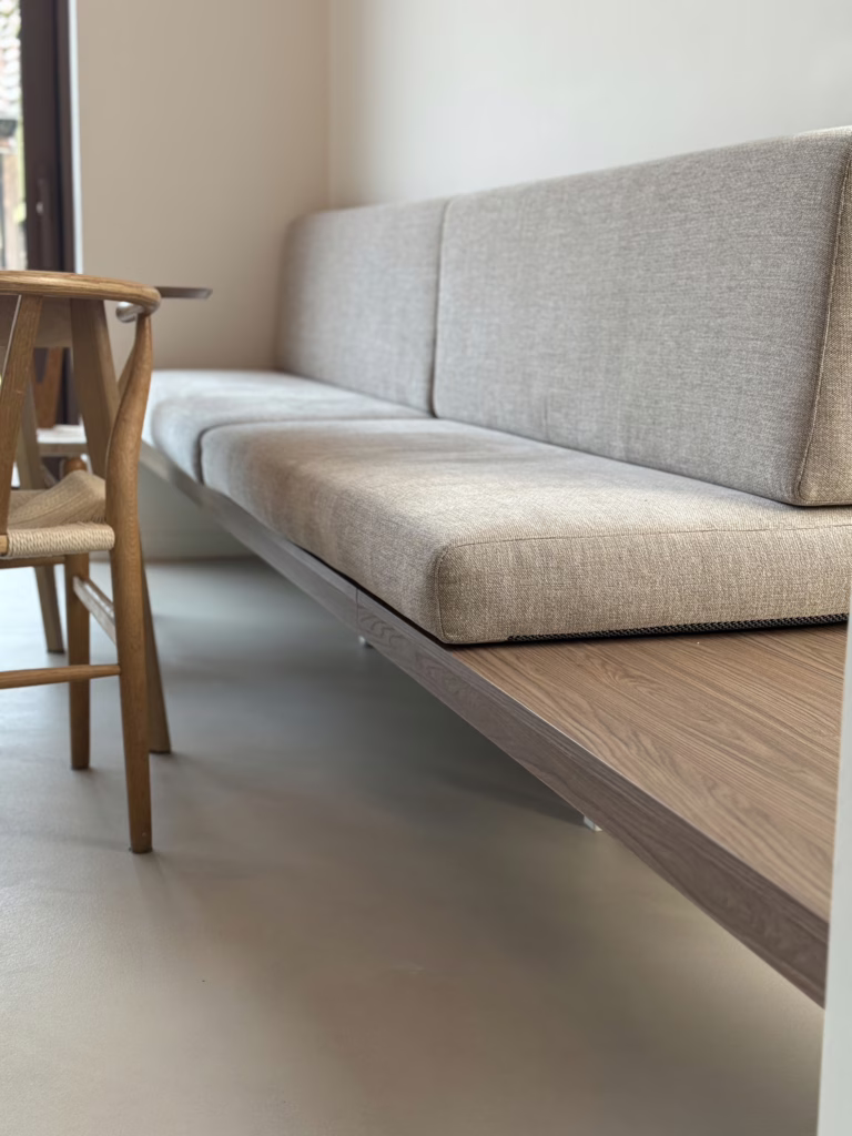 Japandi eetkamer met kwartsiet gietvloer Minimal Sand, ronde eiken tafel en wishbone stoelen — Wijchen