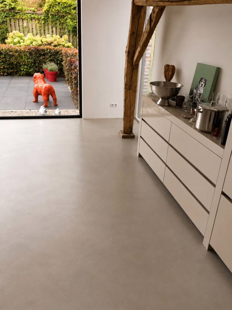 Detail van industriele betonnenvloer in kleur Sand Stone bij de glazen tuindeur, bijgebouw Best