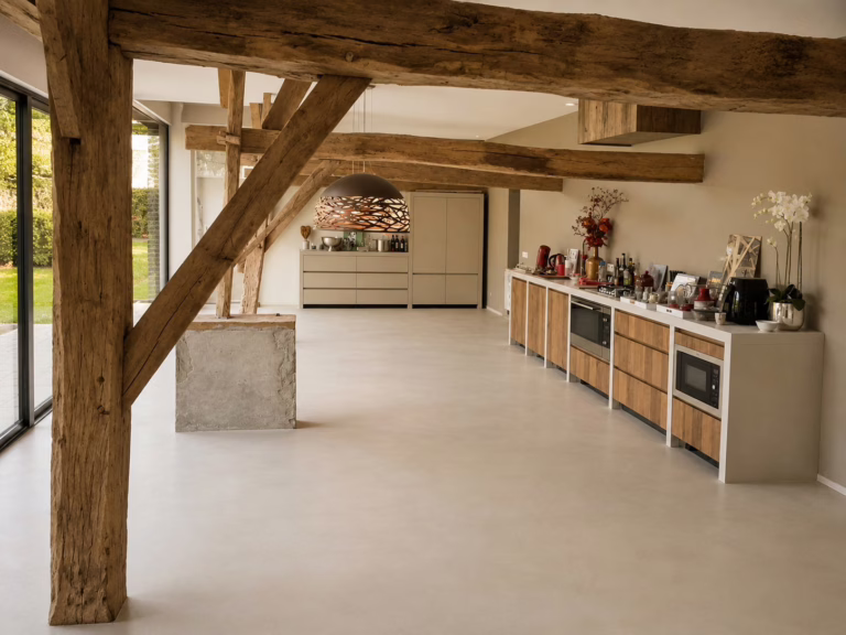 Overzicht van open keuken en eethoek met industriele betonnenvloer in kleur Sand Stone, bijgebouw Best