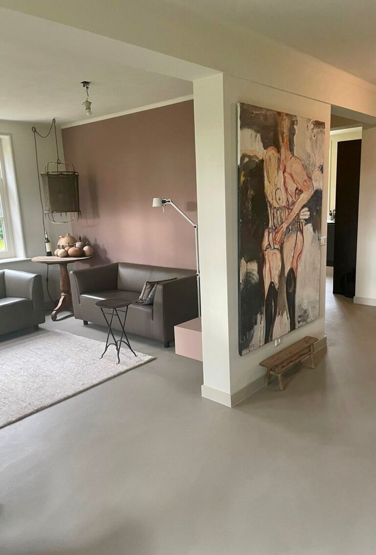 Opstapje naar het verhoogde vloerdeel van het voormalige melkhok, afgewerkt in dezelfde gietvloer
