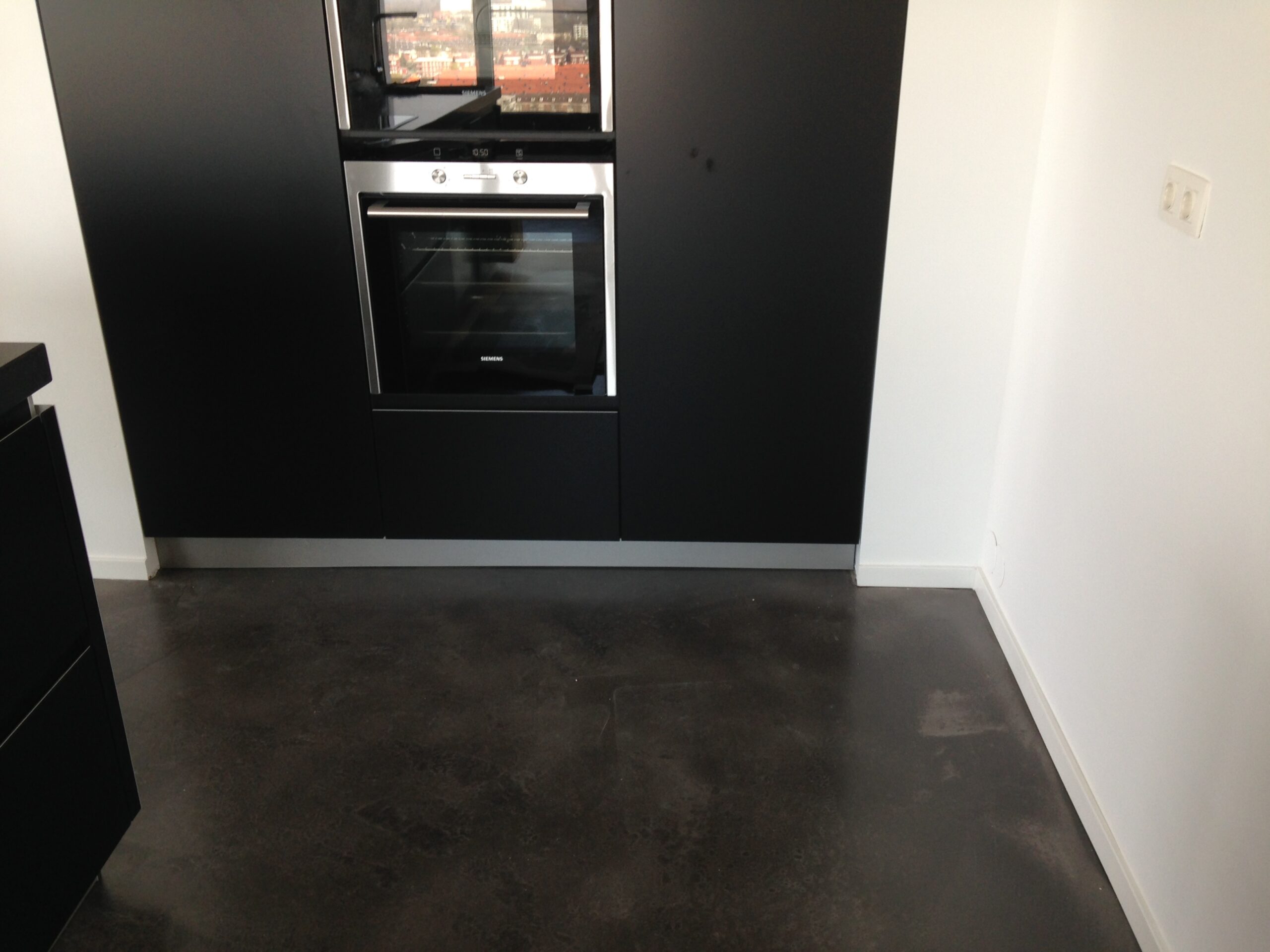 Keuken van een penthouse in 's-Hertogenbosch met een donkergrijze cementgebonden gietvloer