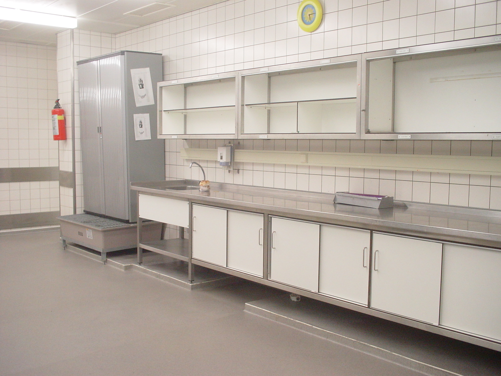 Professionele keuken met roestvrijstalen werkbladen en een naadloze grijze epoxy gietvloer 