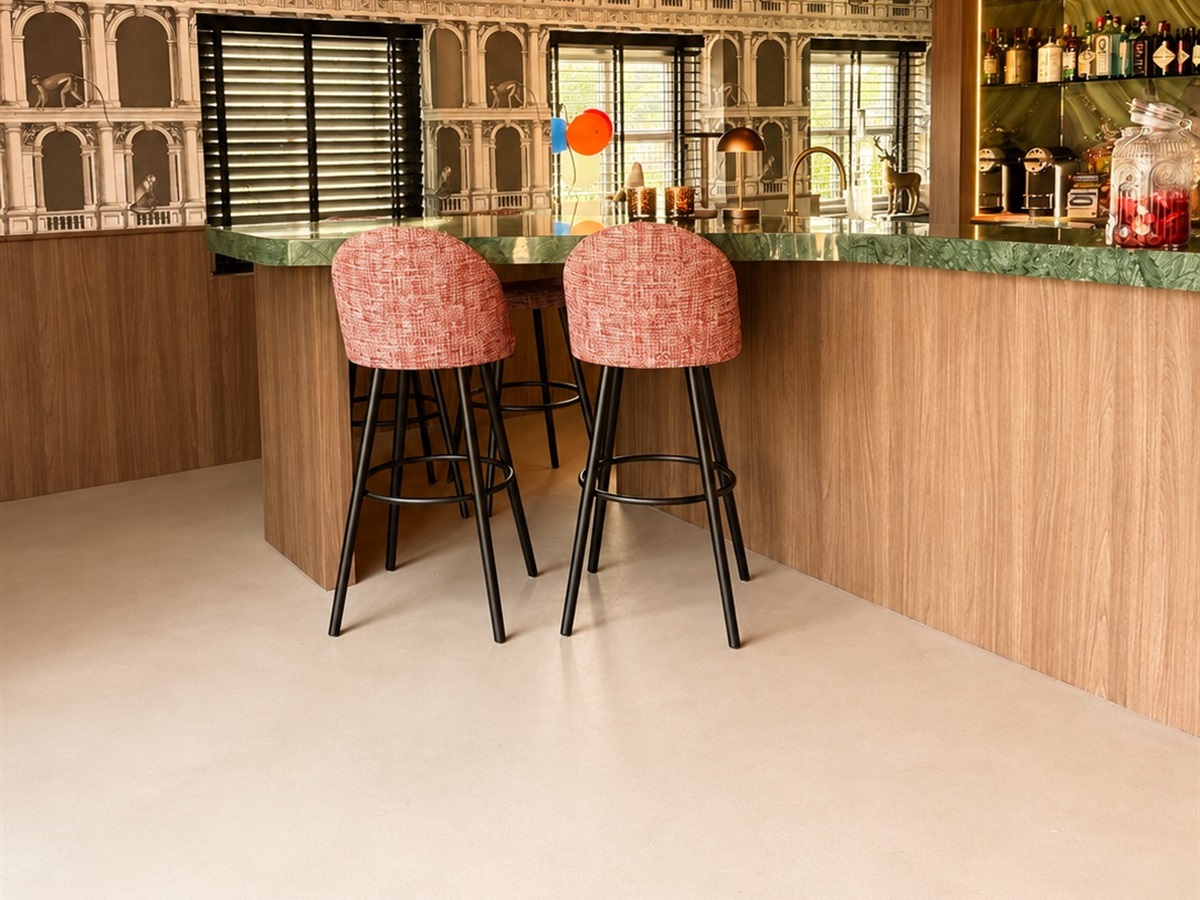 Bar met houten front en groen marmeren blad op een naadloze Minimal Sand gietvloer in de kleur Erta Clay