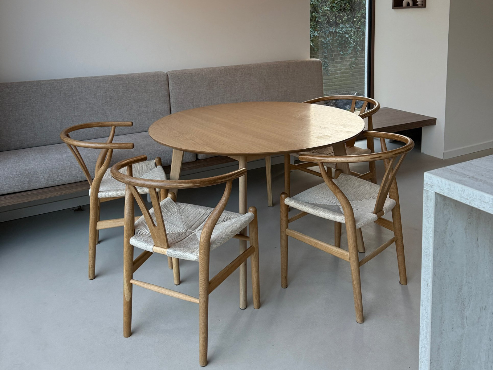 Japandi eethoek in Wijchen met een ronde eikenhouten tafel op een Minimal Sand gietvloer in de kleur Saint Louis